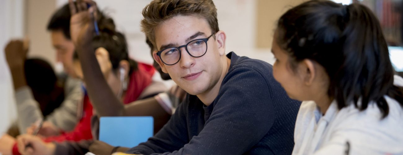 Two students in class talking