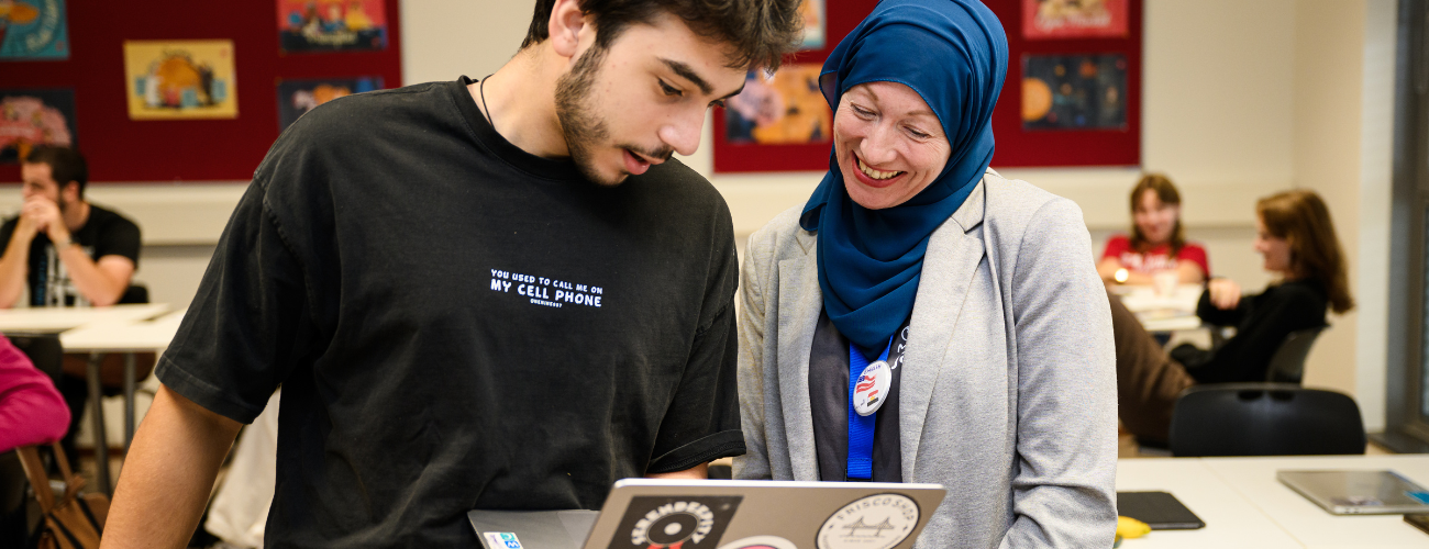 Teacher and student looking at laptop
